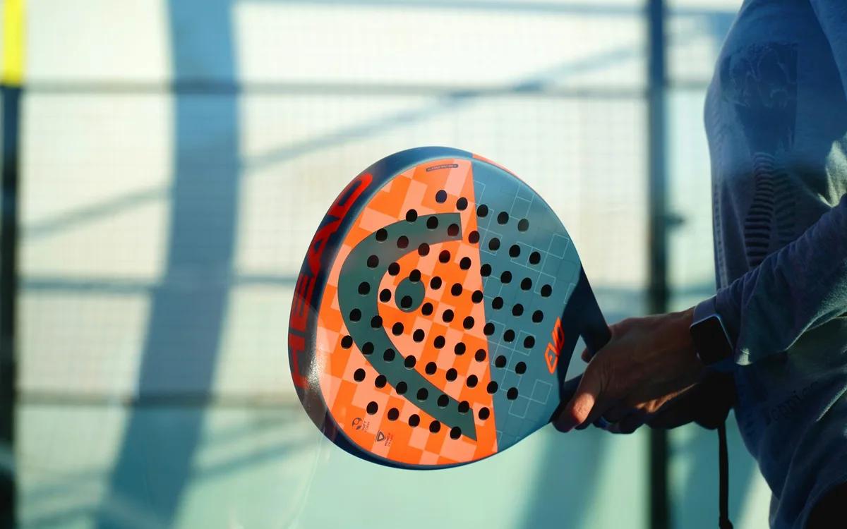 Spieler hält einen orangefarbenen Padelschläger